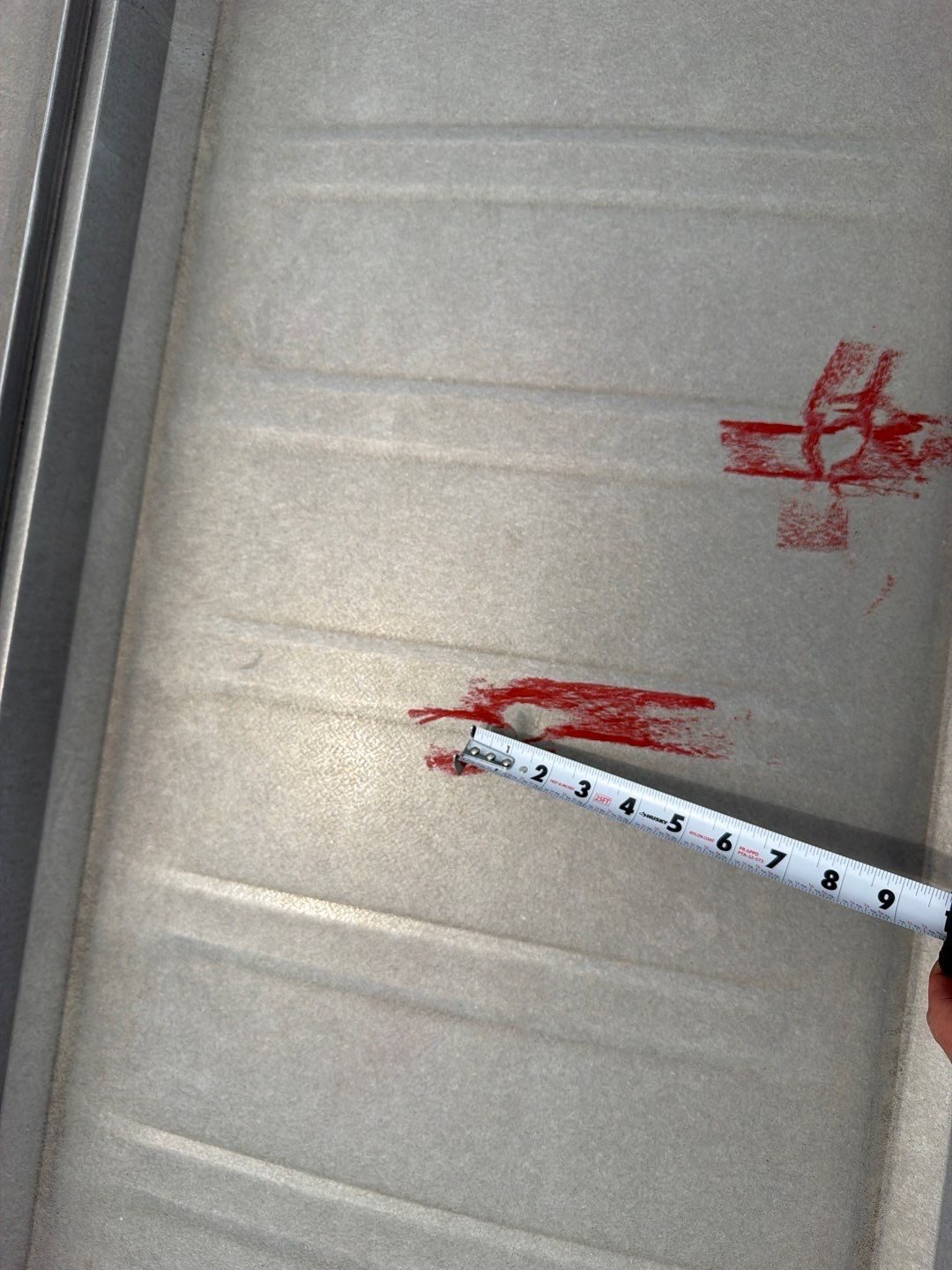 Hail hits marked in red and measured with a tape on a metal roof panel