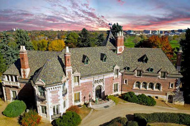 Willbanks Residence, a stone and brick estate with a new tile roof, at sunset