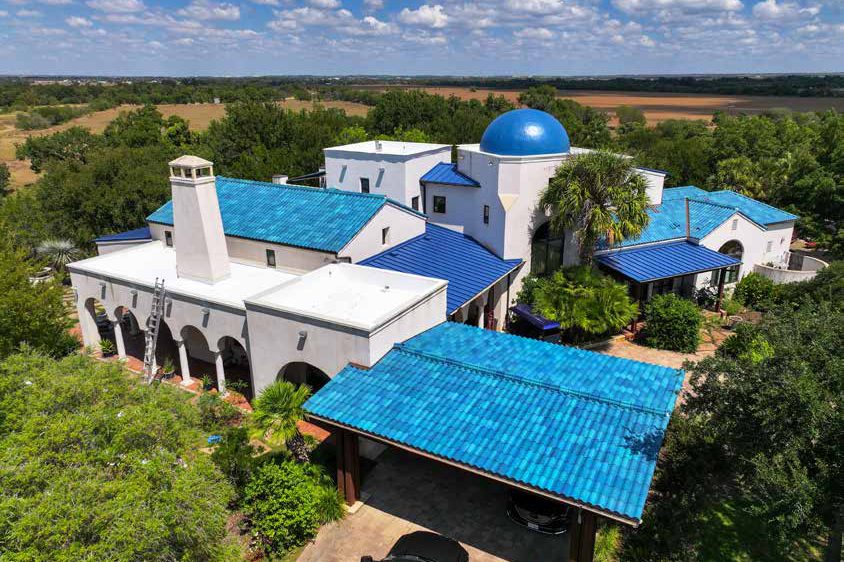 Spanish-style home with a bright blue tile roof