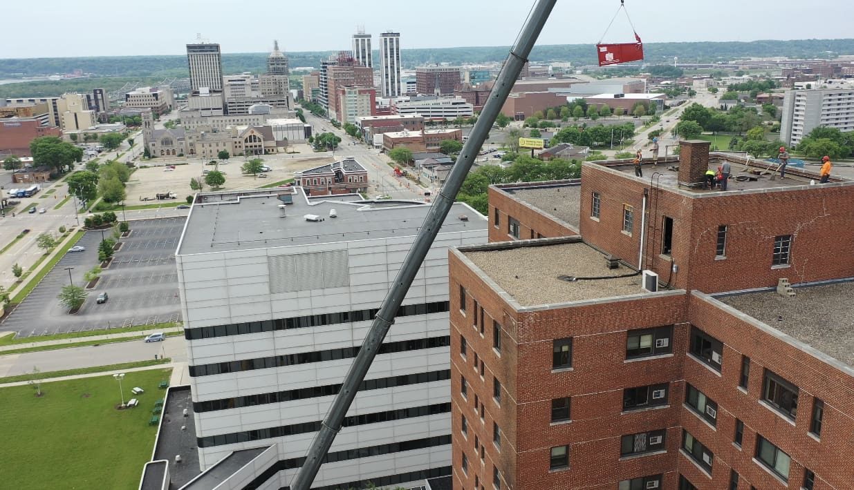Crane lifting materials onto a downtown commercial rooftop
